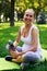 Smiling sportive pregnant woman with bottle of water in park