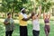 Smiling sports trainer assisting group of senior women enjoying outdoor workout