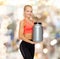 Smiling sporty woman with jar of protein