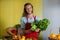 Smiling staff holding leafy vegetables at counter in market