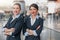 Smiling stewardesses with arms crossed standing in airport terminal