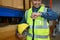 Smiling storehouse worker looking at wristwatch to managing time during working in retail warehouse