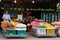 Smiling street fruit seller, baskets with tropical fruits, street trading in Southeast Asia