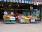 Smiling street fruit seller, baskets with tropical fruits, street trading in Southeast Asia