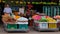 Smiling street fruit seller, baskets with tropical fruits, street trading in Southeast Asia