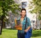 Smiling student with folders, tablet pc and bag