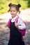 Smiling student girl wearing school backpack. Portrait of happy Caucasian young girl outside the primary school. Smiling