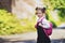 Smiling student girl wearing school backpack. Portrait of happy Caucasian young girl outside the primary school. Smiling