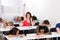 Smiling Student Raising Hand With Classmates Sleeping At Desk