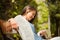 Smiling student sitting on bench text message on her mobile phone