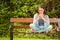 Smiling student sitting on bench text message on her mobile phone