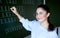 Smiling student stays near blackboard in classroom