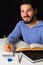 Smiling student using books and taking notes