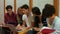 Smiling students using laptop in locker room