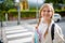 Smiling stylish pupil outdoors in city crossing crosswalk