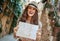 Smiling stylish traveller woman with map in old Italian town