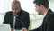 Smiling successful businessmen sitting at table in office