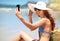 Smiling for a summer selfie. a beautiful young woman taking a selfie at the beach.