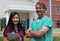 Smiling Surgeon and Asian Nurse Stand Outside Hospital