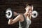 Smiling Sweat beautiful girl lifting dumbbells