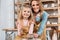 smiling teacher and child painting ceramic pot together