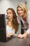 Smiling teacher and student behind desk at computer