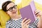 smiling teen boy reading violet book