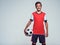 Smiling teen boy in sportswear holding soccer ball