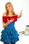 Smiling teen girl with book showing thumbs up