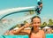 Smiling teen girl enjoing summer vacation at the pool with fly board watershow on the background