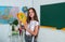 smiling teen girl hold protractor in school classroom, math