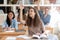 Smiling teen girl student raising hand, asking question at lesson