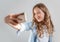 Smiling teen making selfie photo on smartphone over white background  cute girl