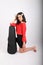 Smiling teenage girl kneeling with violin case