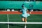 Smiling teenage girl messing around, dancing on tennis court, taking a break