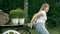 Smiling teenage girl pushing vintage wooden cart outdoors