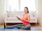 Smiling teenage girl streching on floor at home