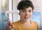 Smiling teenager boy with white paint roller and dirty face make repaint