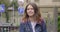 Smiling teenager girl with purple hair in denim jacket walking in the old tourist town