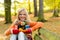 Smiling teenager girl sitting autumn park bench