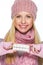 Smiling teenager girl in winter hat and scarf showing pills pack