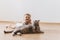 smiling toddler boy and grey british shorthair cat lying on floor together