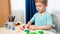 Smiling toddler boy shaping and sculpting forms and shapes with colroful dough or plasticine. Using toy clay in