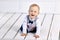 Smiling toddler crawls on flor in lounge.