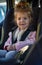 Smiling toddler girl buckled into her car seat