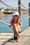 Smiling toddler girl posing like a pro model sitting on a pier