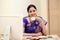 Smiling traditional woman drinking coffee at her desk