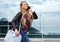 Smiling travel girl with bag talking on mobile phone