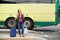 Smiling travel woman standing at bus terminal with bags