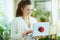 Smiling trendy woman using gift laptop with red bow